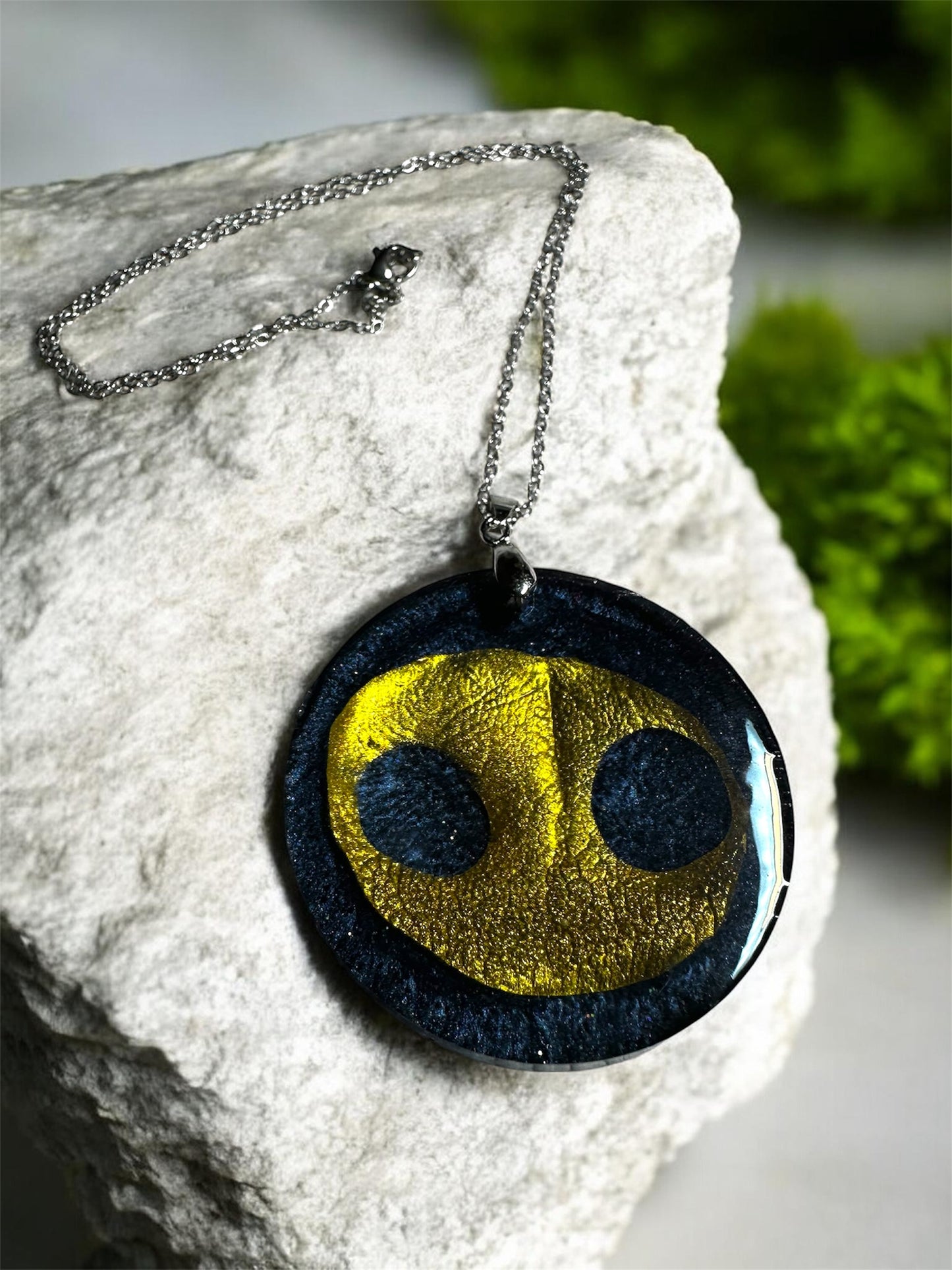 Runder Gedenkschmuck Anhänger mit goldenem Hundenasen-Abdruck an einer Silberkette.
