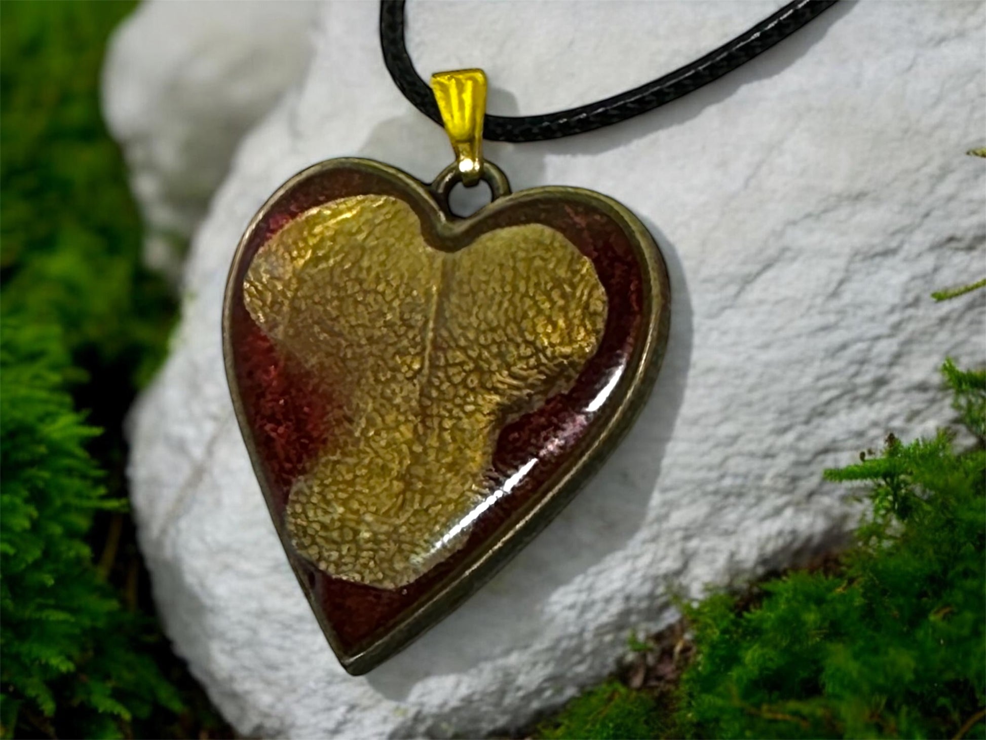 Gedenkschmuck Anhänger in Herzform mit goldenem Hundenasen-Abdruck in Epoxidharz.