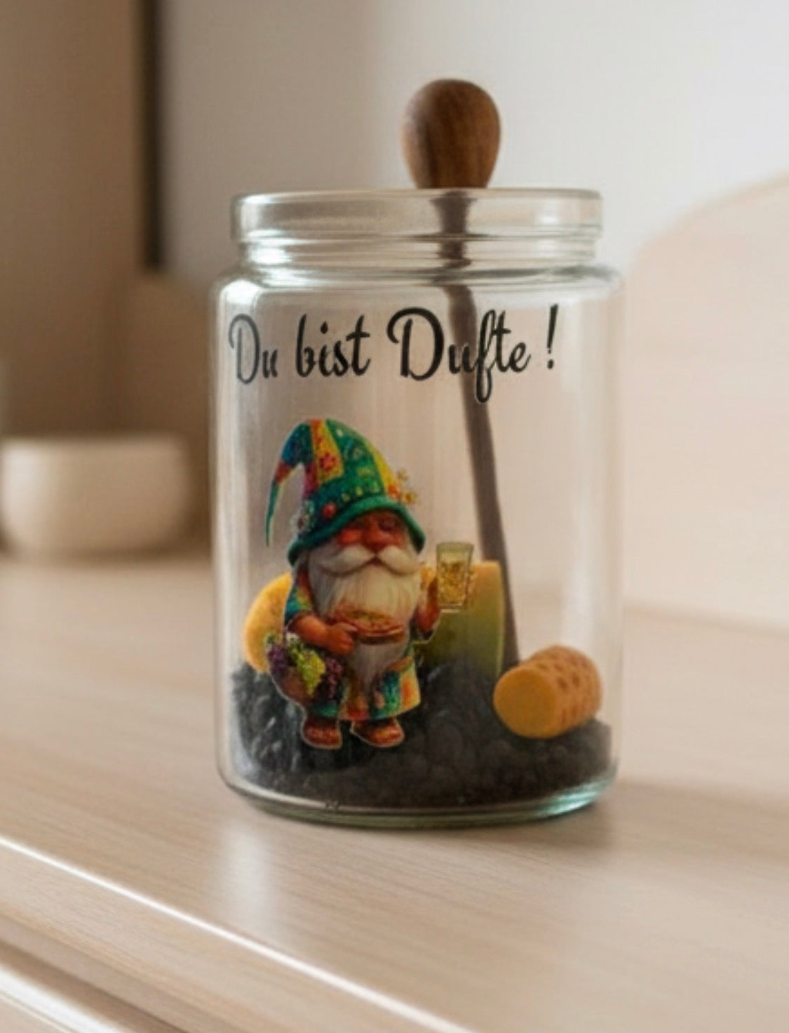 Zylindrisches Duftglas mit dem Motiv eines Pfälzer Wichtels mit Schoppenglas, gefüllt mit dunklem Granulat und der Aufschrift „Du bist Dufte!“. Dufte Geschenkidee aus der Pfalz