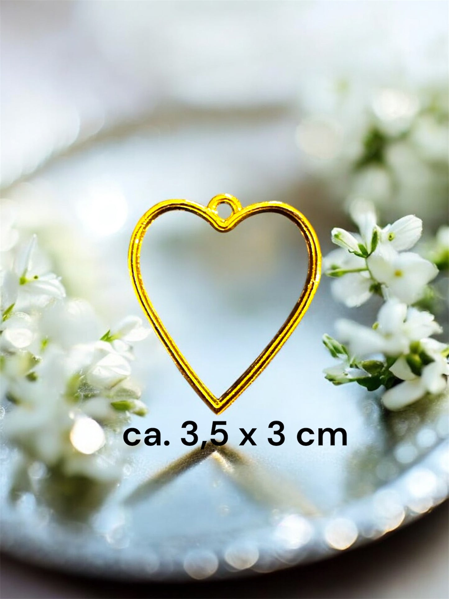 Größenvergleich einer herzförmigen Gedenkschmuck Fassung in Gold mit den Maßen ca. 3,5 x 3 cm.