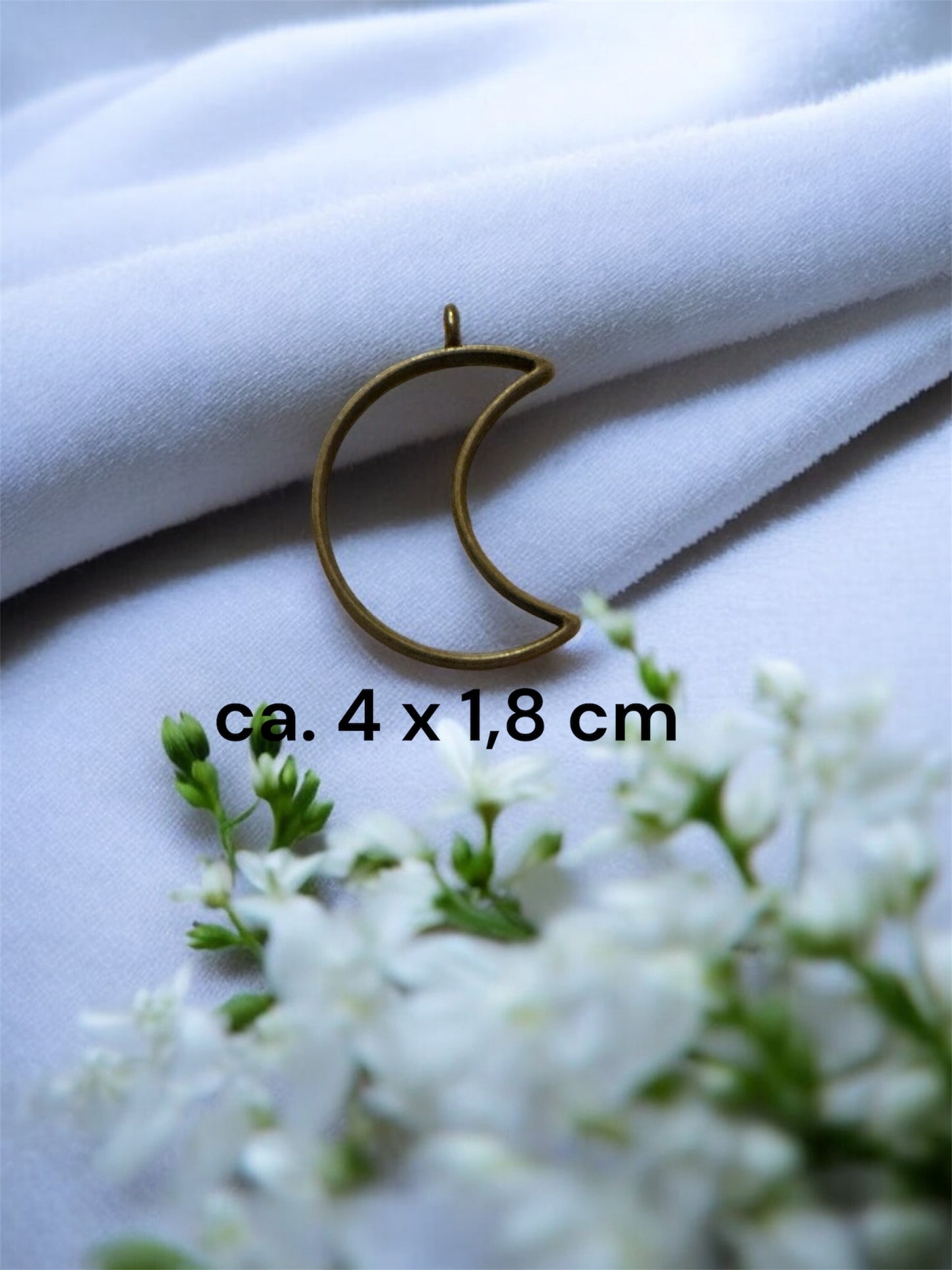 Größenvergleich einer mondförmigen Gedenkschmuck Fassung aus Messing mit den Maßen ca. 4 x 1,8 cm.