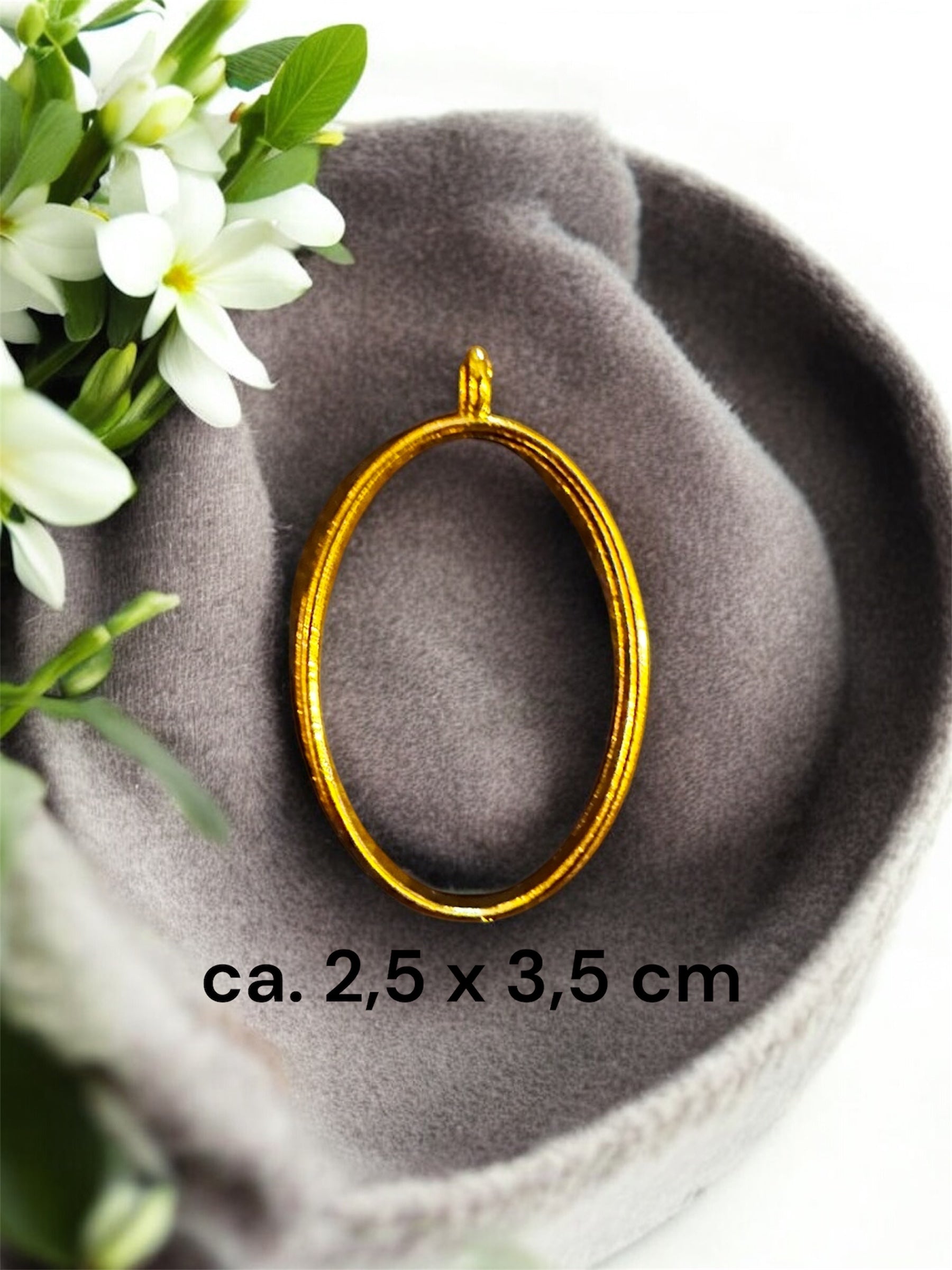 Größenvergleich einer ovalen Gedenkschmuck Fassung in Gold mit den Maßen ca. 2,5 x 3,5 cm.