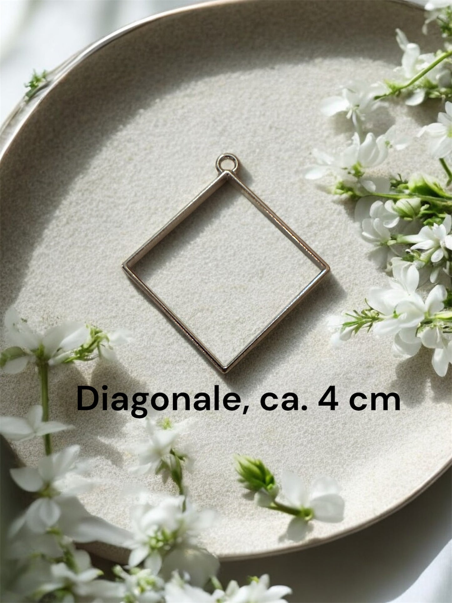 Größenvergleich einer quadratischen Gedenkschmuck Fassung in Silber-Optik mit einer Diagonale von ca. 4 cm.
