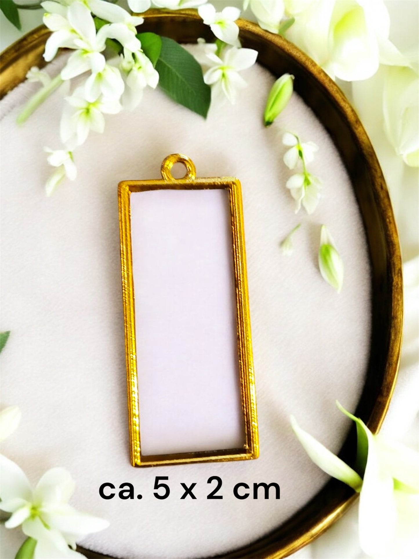 Größenvergleich einer rechteckigen Gedenkschmuck Fassung in Gold mit den Maßen ca. 5 x 2 cm.
