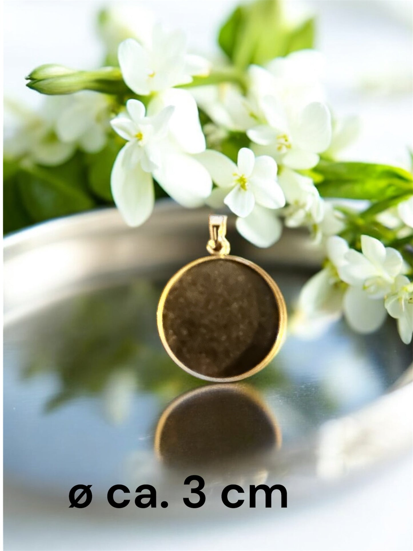 Größenvergleich eines runden Gedenkschmuck Anhängers in Gold-Optik mit ca. 3 cm Durchmesser.