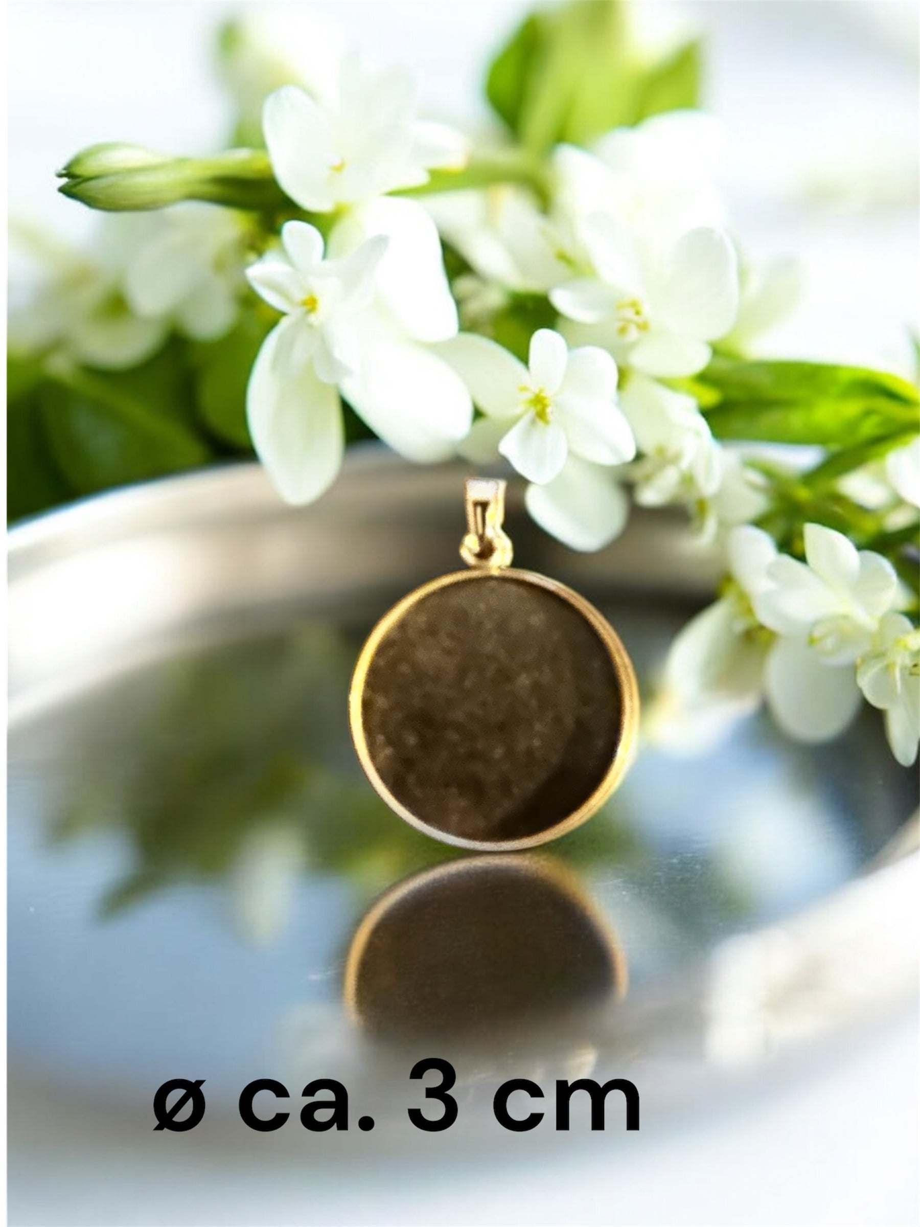 Größenvergleich eines runden Gedenkschmuck Anhängers in Gold-Optik mit ca. 3 cm Durchmesser.