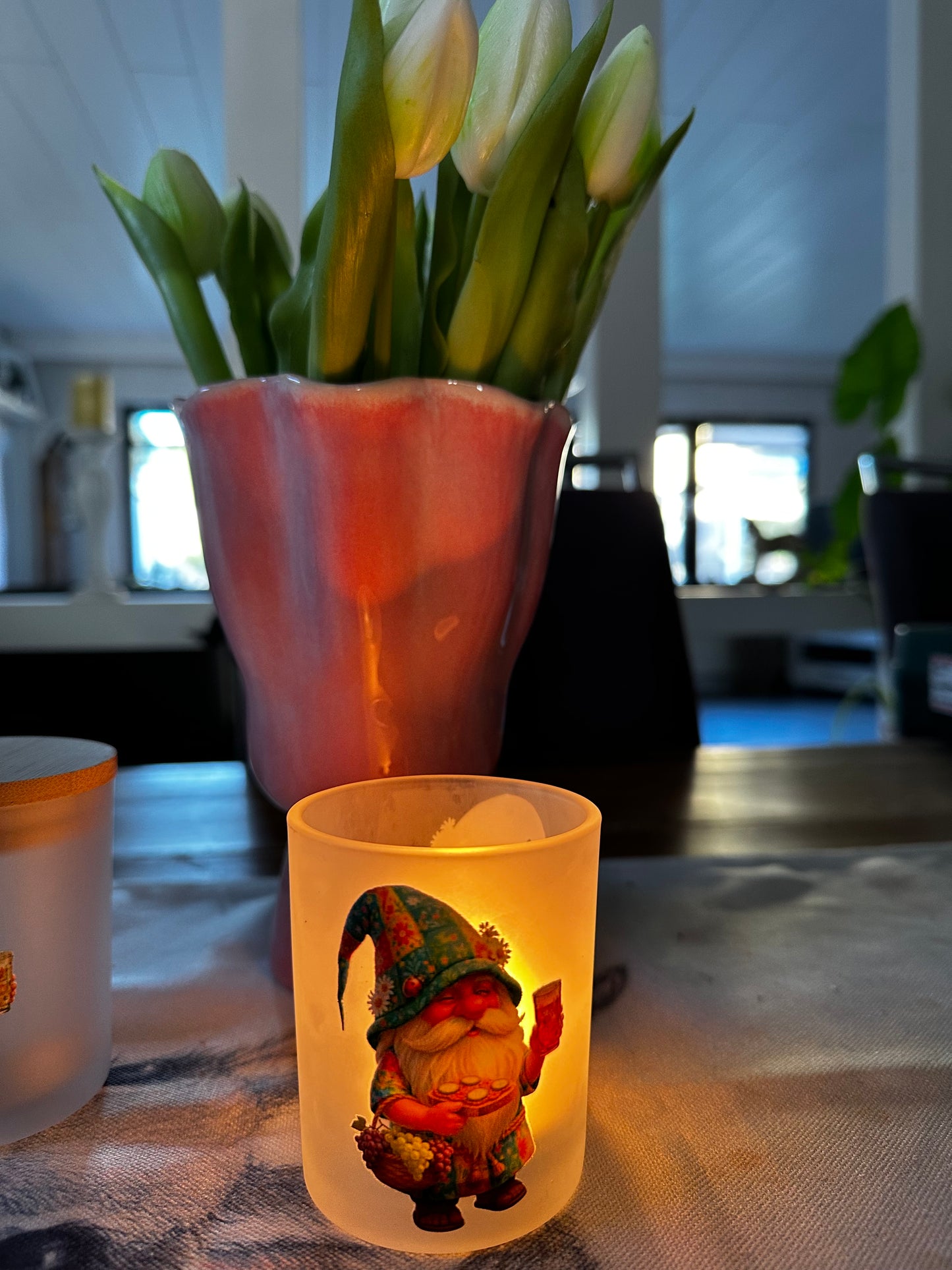 Beleuchtetes Gnodel-Windlicht aus gefrostetem Glas mit Pfälzer Wichtel-Motiv in einer gemütlichen Wohnzimmer-Dekoration.